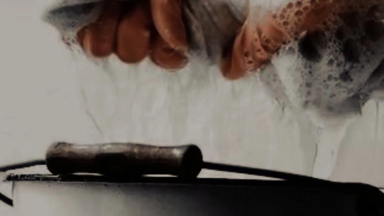 Hands wringing a cloth over a bucket