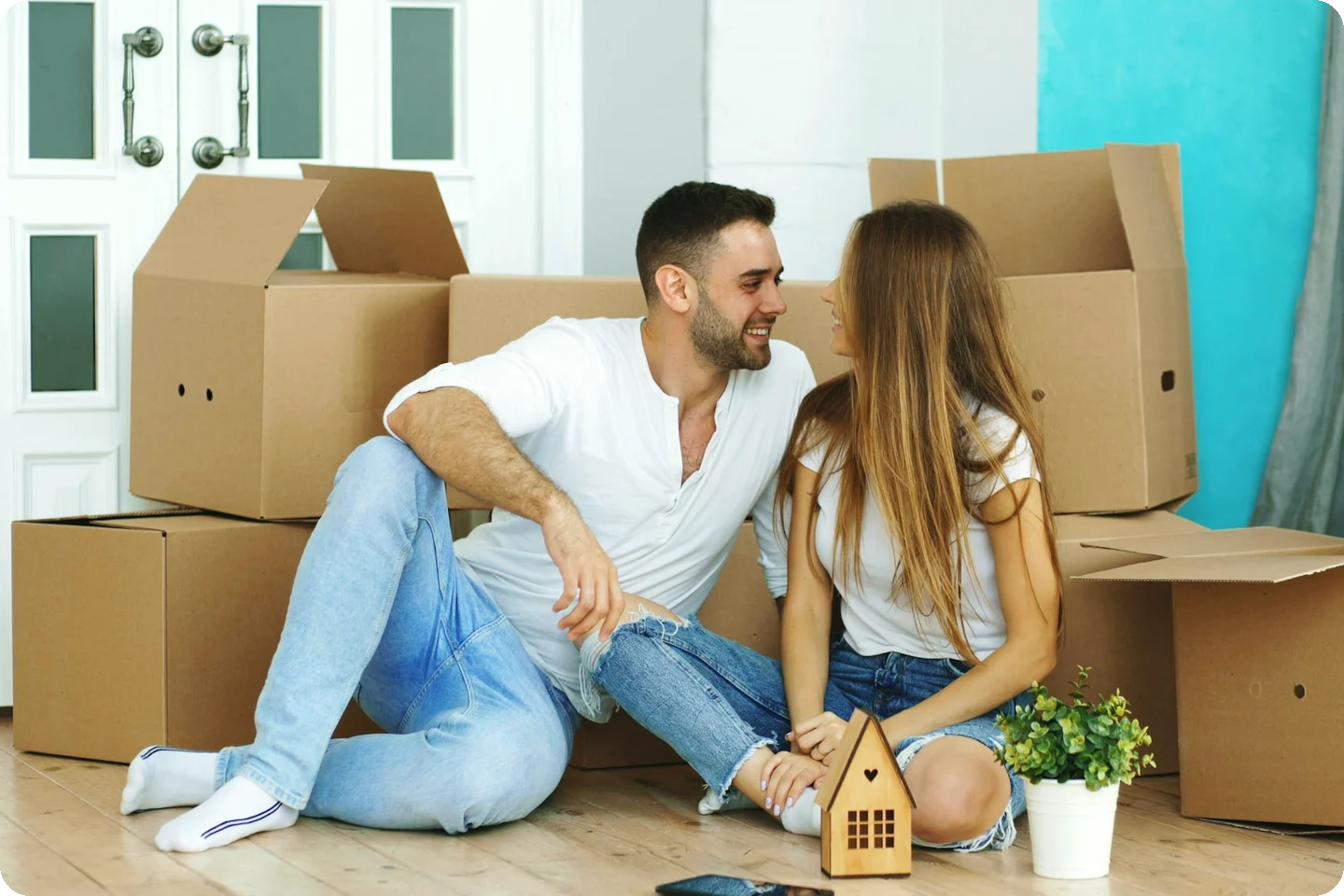 A couple carrying a box into their new home on moving day